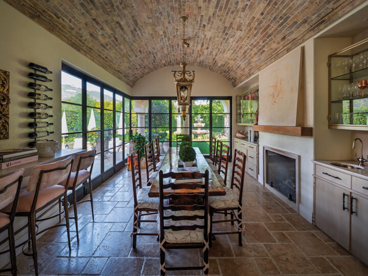 The home’s dining-reading room opens onto a patio with a firepit. The ceiling, centered with an antique chandelier, is set with old bricks from France