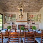 The home’s dining-reading room opens onto a patio with a firepit. The ceiling, centered with an antique chandelier, is set with old bricks from France
