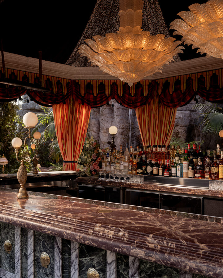 It’s the blue lagoon reimagined as Night Hawk, an open-fire Greek restaurant. Rock-formed booths and banquettes create nooks from which to review the overwrought design