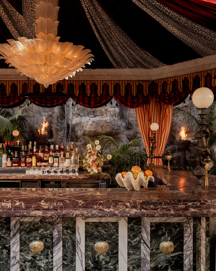 It’s the blue lagoon reimagined as Night Hawk, an open-fire Greek restaurant. Rock-formed booths and banquettes create nooks from which to review the overwrought design