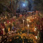 A sweet grandma sits quietly among the gravestones within this elaborately decorated cemetery in Oaxaca