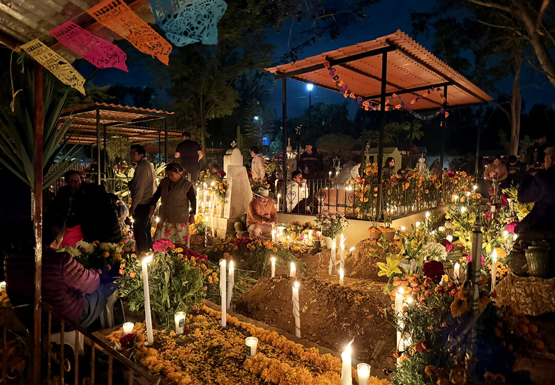 The tradition of Dia de los Muertos brings families to the gravesites of beloved family members to honor them with candles, flowers, and colorful memorabilia