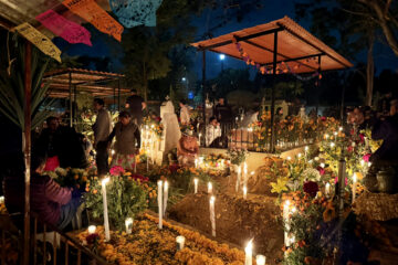 The tradition of Dia de los Muertos brings families to the gravesites of beloved family members to honor them with candles, flowers, and colorful memorabilia