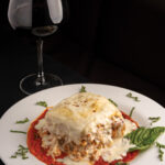 Lasagne Firenze: layered with ricotta cheese, beef, chicken, sausage, roma tomato, mushroom, and parmigiano-reggiano, with marinara sauce and creamy bechamel